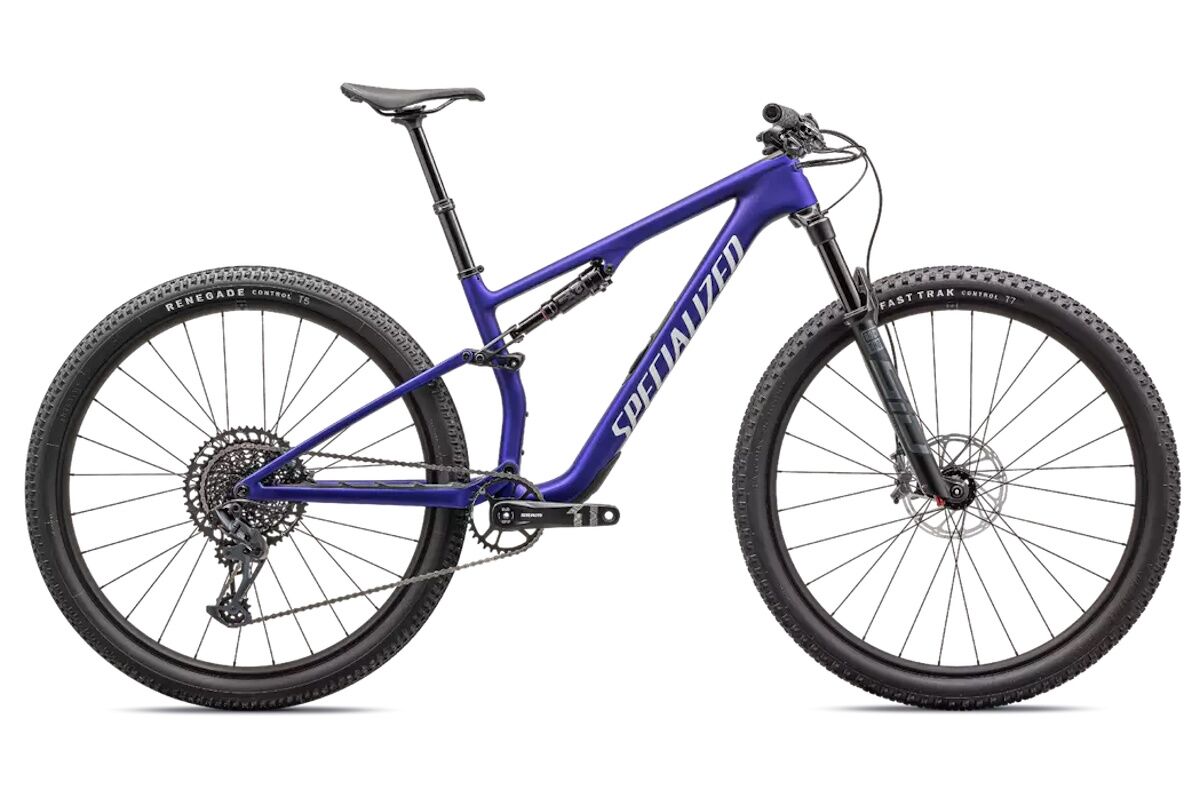 "Bicicleta Specialized Epic 8 Comp 2024 MTB XC carbono FACT 11m, horquilla RockShox SID Select 120mm, transmisión GX Eagle 12 velocidades, ruedas de aluminio, frenos Level Bronze Stealth, vista lateral en sendero de cross country"